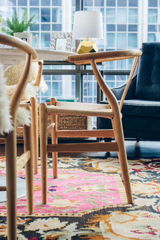 Woven wishbone chairs add style and sophistication to this small apartment dining space while feeling casual, yet architectural.